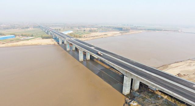 臺(tái)輝高速項(xiàng)目黃河特大橋?yàn)r青面層攤鋪圓滿結(jié)束